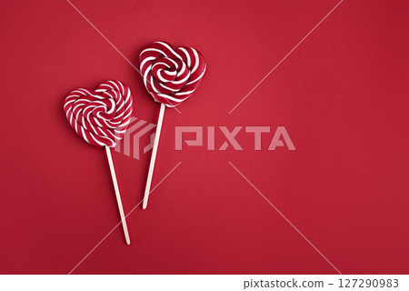 Heart lollipops candy on a stick on red background Heart lollipops candy on a stick on red background 127290983