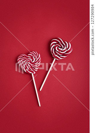 Heart lollipops candy on a stick on red background Heart lollipops candy on a stick on red background 127290984