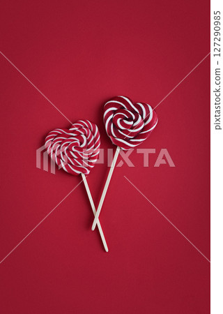 Heart lollipops candy on a stick on red background 127290985