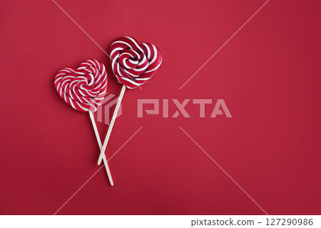 Heart lollipops candy on a stick on red background Heart lollipops candy on a stick on red background 127290986