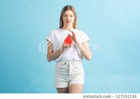 Woman holding red blood drop mockup as symbol of blood donation 127291198