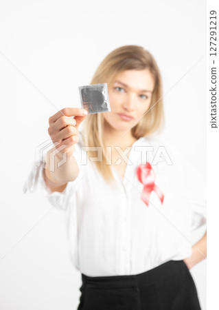 Woman with condom and red ribbon 127291219