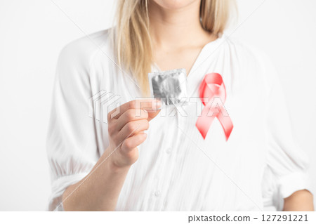 Woman with condom and red ribbon 127291221