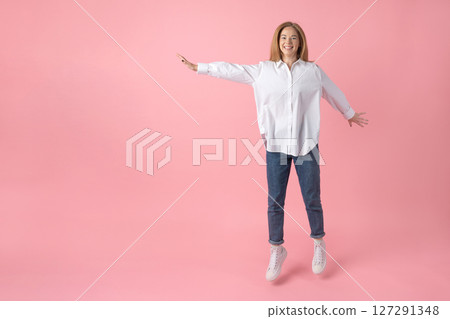 Happy Woman Jumping Against Pink Background Happy Woman Jumping Against Pink Background 127291348
