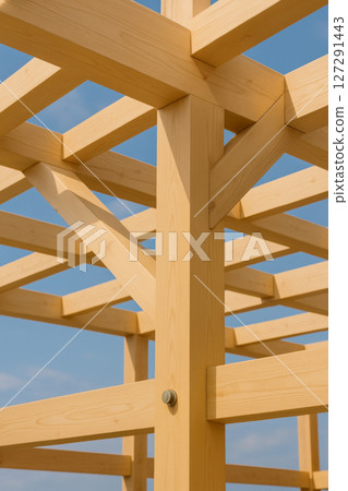 Wooden beam construction detail of country house against blue sky, background 127291443