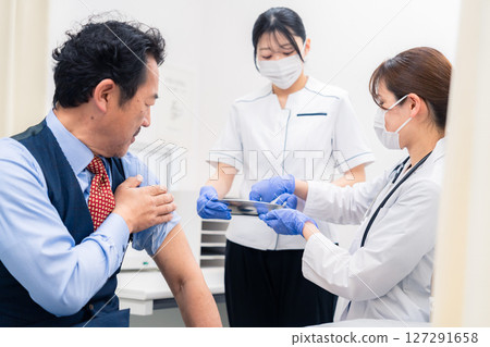 一名女醫務人員正在接種疫苗並抽血 一名女醫務人員正在接種疫苗並抽血 127291658