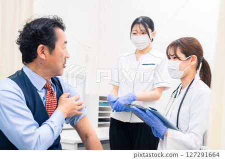 A female medical worker administering a vaccine and taking blood A female medical worker administering a vaccine and taking blood 127291664