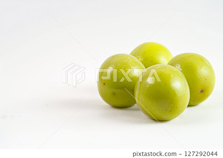 Four green plums are sitting on a white background 127292044