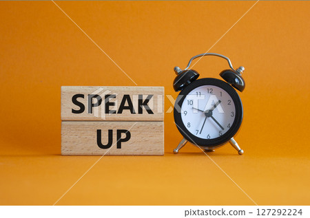 Speak Up symbol. Wooden blocks with words Speak Up Beautiful orange background with alarm clock. Business and Speak Up concept. Copy space. 127292224
