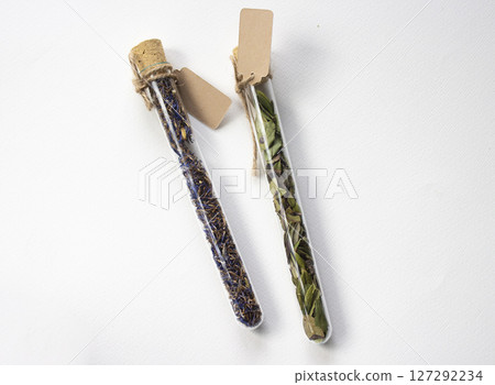 Glass tubes with Dried flowers and herbs. Paper tags with copy space 127292234