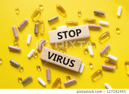 Stop Virus symbol. Concept word Stop Virus on wooden blocks. Beautiful yellow background with pills. Medicine and Stop Virus concept. Copy space Stop Virus symbol. Concept word Stop Virus on wooden blocks. Beautiful yellow background with pills. Medicine and Stop Virus concept. Copy space 127292445