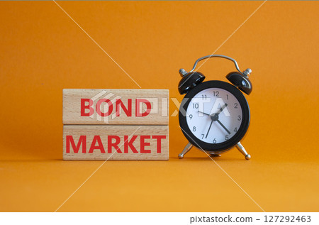 Bond Market symbol. Concept words Bond Market on wooden blocks. Beautiful orange background with alarm clock. Business and Bond Market concept. Copy space. 127292463