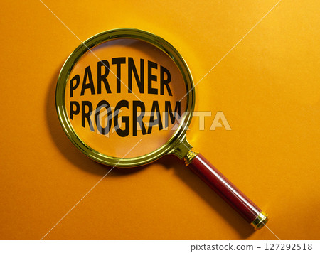 Partner Program symbol. Concept words Partner Program on magnifying glass. Beautiful orange background. Business and Partner Program concept. Copy space. 127292518