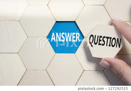 Answer or Question symbol. Concept word Answer or Question on wooden comb puzzle. Businessman hand. Beautiful blue background. Business and Answer or Question concept. Copy space 127292525