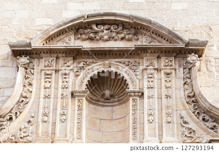 Intricate stone architecture featuring ornate shell motif on historic building exterior 127293194