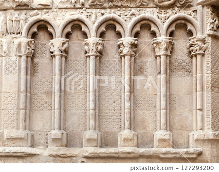 Detailed stone carvings of columns and arches on ancient church wall in a historic location 127293200