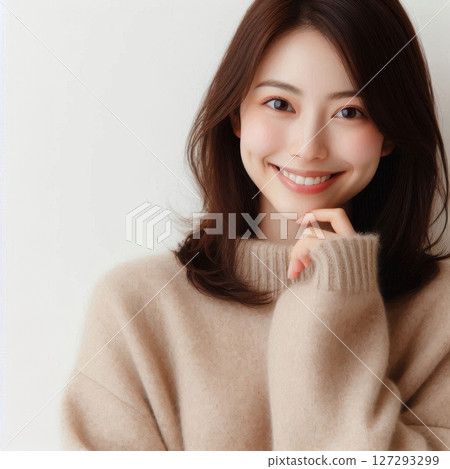 A beautiful Japanese woman with short hair smiles warmly while touching her chin, wearing an elegant sweater and illuminated by soft natural side light. 127293299