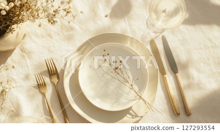 Elegant breakfast table with vintage china and modern flatware in soft light. 127293554