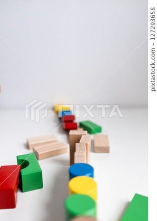 Colorful wooden toy blocks arranged in a creative pattern on white surface Colorful wooden toy blocks arranged in a creative pattern on white surface 127293658
