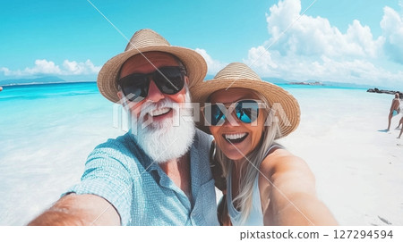 Couple enjoys a sunny day at the beach with clear blue waters and white sand 127294594