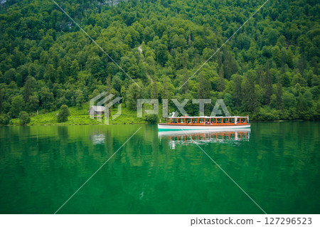 Konigssee Lake in Bavaria Germany with Church by the Lake White Boat Forested Mountain and Beautiful Sunny Trekking in Berchtesgaden German Alps. High quality photo Konigssee Lake in Bavaria Germany with Church by the Lake White Boat Forested Mountain and Beautiful Sunny Trekking in Berchtesgaden German Alps. High quality photo 127296523