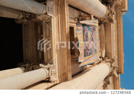 Tapestry banner hanging from the columns of Saint Peters Basilica facade in Vatican City for special religious event or papal blessing under blue sky. High quality photo 127296568