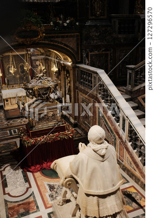 Elevated chapel and sculptural tomb in Basilica of Saint Mary Major featuring Christmas garlands detailed wall art and religious statuary under gold-painted architectural arches. High quality photo 127296570