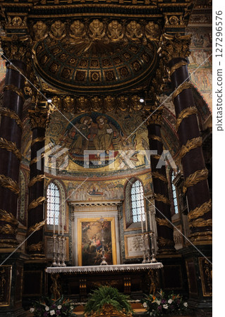Elevated chapel and sculptural tomb in Basilica of Saint Mary Major featuring Christmas garlands detailed wall art and religious statuary under gold-painted architectural arches. High quality photo 127296576