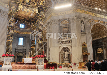 Ornate Baldachin canopy over Papal Altar in Saint Peters Basilica Vatican City designed by Gian Lorenzo Bernini with twisted bronze columns red floral decorations and Latin inscriptions under grand 127296612