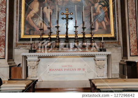Tomb and altar of Saint John Paul II inside Saint Peters Basilica featuring gold sacred paintings and marble design commemorating the late pope. High quality photo 127296642