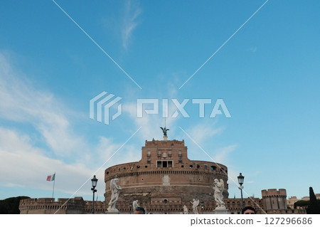Daytime view of Castel Sant Angelo and Ponte Sant Angelo in Rome with tourists walking along the Tiber River historic architecture and clear blue sky. High quality photo Daytime view of Castel Sant Angelo and Ponte Sant Angelo in Rome with tourists walking along the Tiber River historic architecture and clear blue sky. High quality photo 127296686