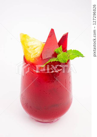 red beet or berry smoothie with pineapple slice and mint garnish served in transparent glass on white background. High quality photo 127296826