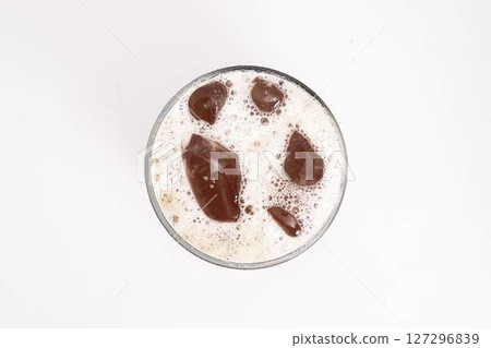 iced coffee or cold brew in tall clear glass with ice cubes and creamy foam served on white background. High quality photo 127296839