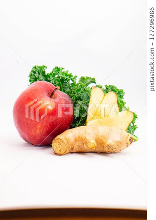 fresh red apple ginger root and curly kale leaves arranged on clean white background for healthy food and juice ingredients concept. High quality photo 127296986