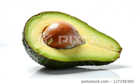Freshly cut avocado showcasing creamy texture and vibrant color with a single seed in the center on a white background 127298360
