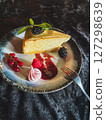 Piece of cheesecake with fresh berries and mint on dark background 127298639