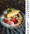 Piece of cheesecake with fresh berries and mint on dark background 127298640