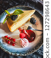 Piece of cheesecake with fresh berries and mint on dark background 127298643