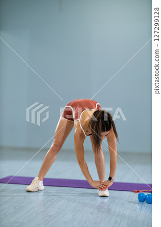 girl athlete engages in standing oblique twists in gym setting She maintains focus as she enhances her core strength and flexibility in dedicated workout space girl athlete engages in standing oblique twists in gym setting She maintains focus as she enhances her core strength and flexibility in dedicated workout space 127299128