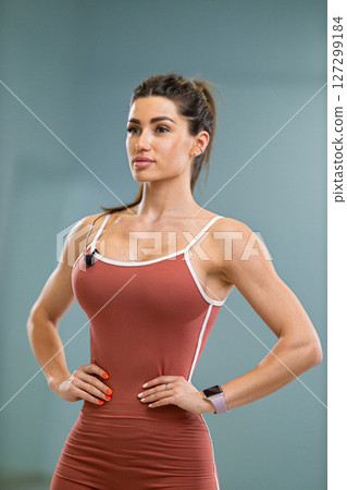 Sporty girl announcer stands poised and confident at a fitness event, wearing a stylish outfit and engaging the audience with her lively presence in a well lit studio Sporty girl announcer stands poised and confident at a fitness event, wearing a stylish outfit and engaging the audience with her lively presence in a well lit studio 127299184