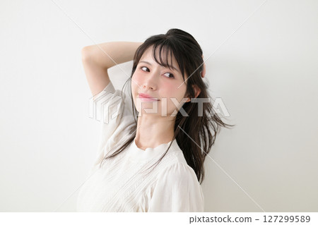 A woman touching her hair A woman touching her hair 127299589
