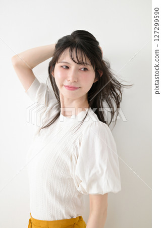 A woman touching her hair A woman touching her hair 127299590