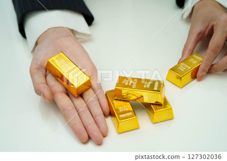Asian woman holding gold bar in finance business. 127302036