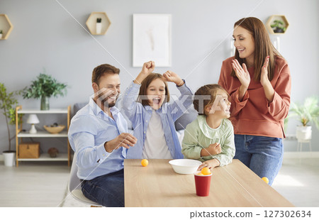 Young family with kids having fun together at home on weekend playing and throwing tennis balls Young family with kids having fun together at home on weekend playing and throwing tennis balls 127302634