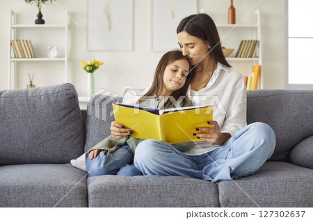 Mother and daughter reading book, story having happy time at home, joy with preschool child Mother and daughter reading book, story having happy time at home, joy with preschool child 127302637