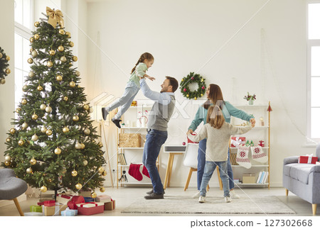 Happy family having fun with children in the living room at home near decorated Christmas fir tree. 127302668