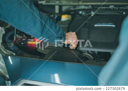 Auto mechanic checking oil 127302679