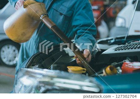 Auto mechanic filling engine oil Auto mechanic filling engine oil 127302704