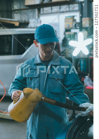 Auto mechanic filling engine oil Auto mechanic filling engine oil 127302711