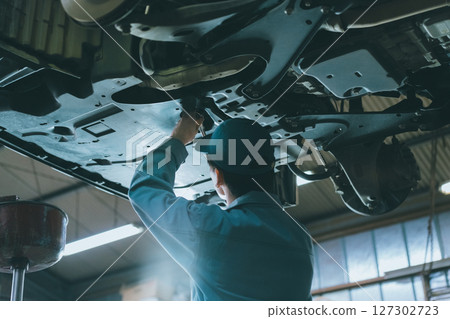 Auto mechanic changing oil Auto mechanic changing oil 127302723
